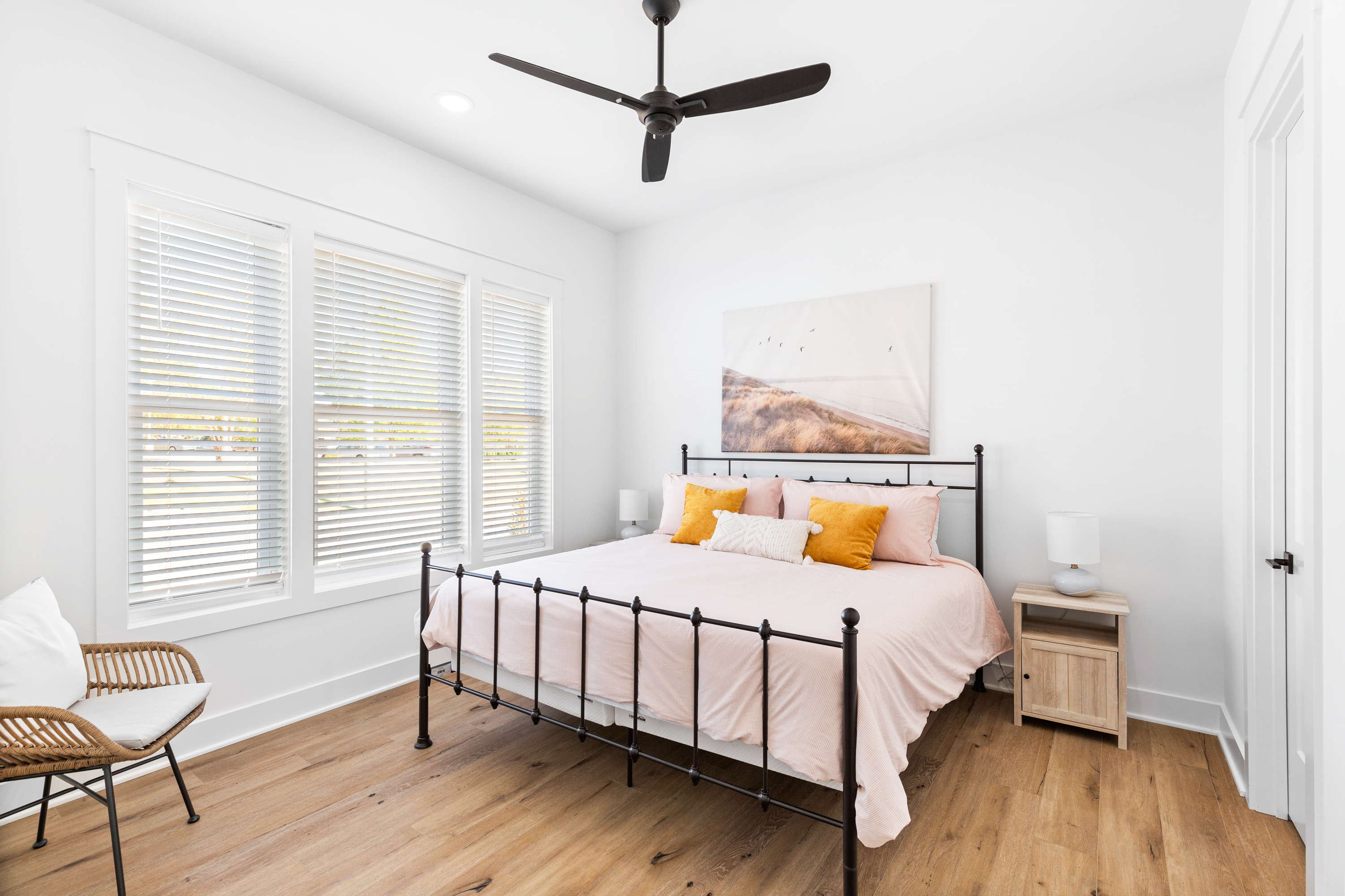 Minimalist bedroom with a cozy bed, large windows, and soft decor